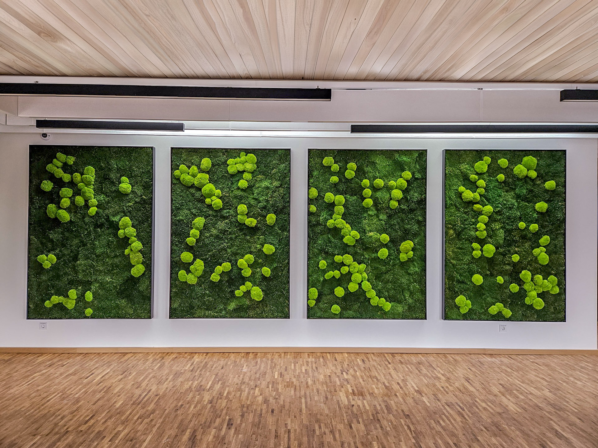 Vier großformatige Moosbilder von Mission Green GmbH als Wandinstallation in einem modernen Büro- oder Veranstaltungsraum.